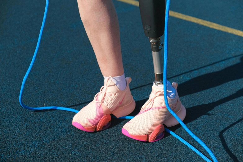 a pair of feet with blue shoelaces attached to an air pump