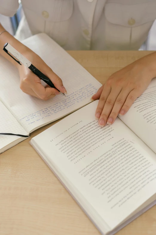 a girl in white uniform is writing on some books