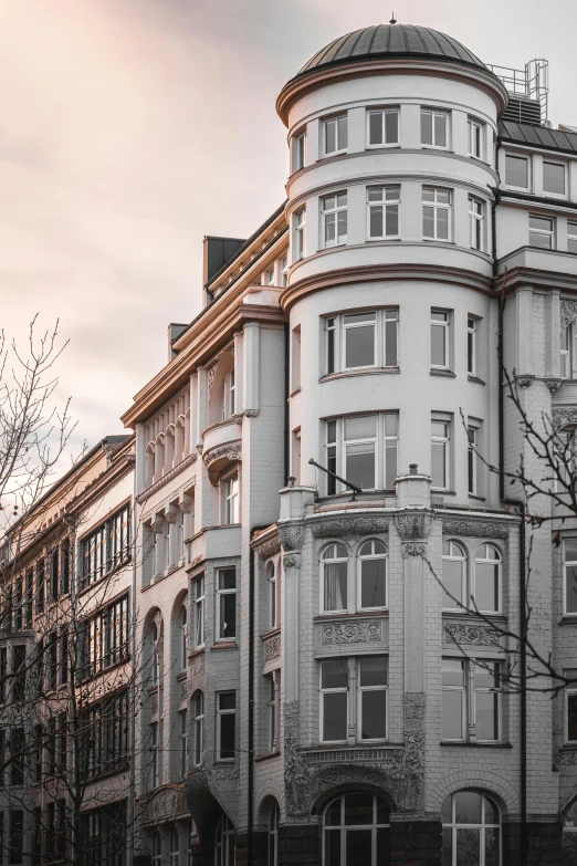 a white building in front of several brown building