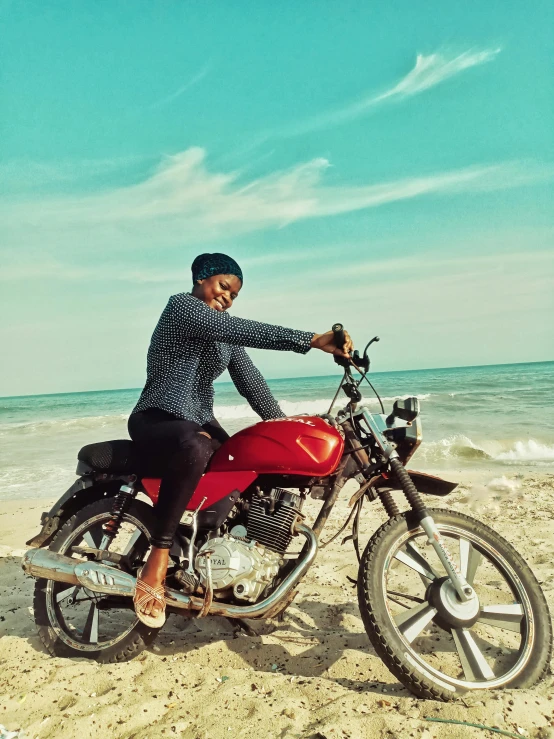 man riding a motorcycle on the beach on a sunny day