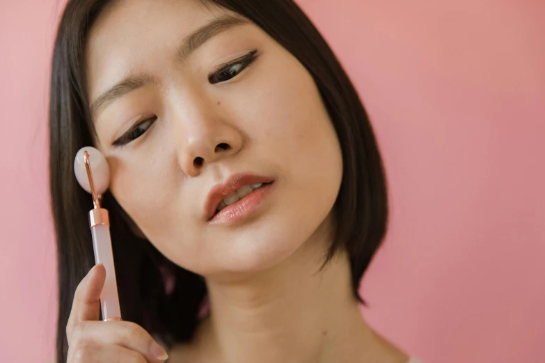 a young asian woman brushing her brow with a brush