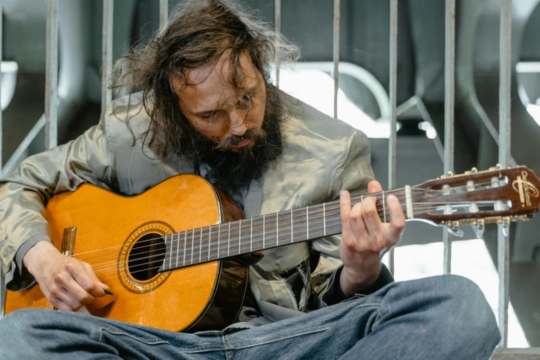 a man holding a guitar on top of a street