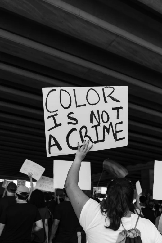 a group of people holding protest signs that read color is not a crime