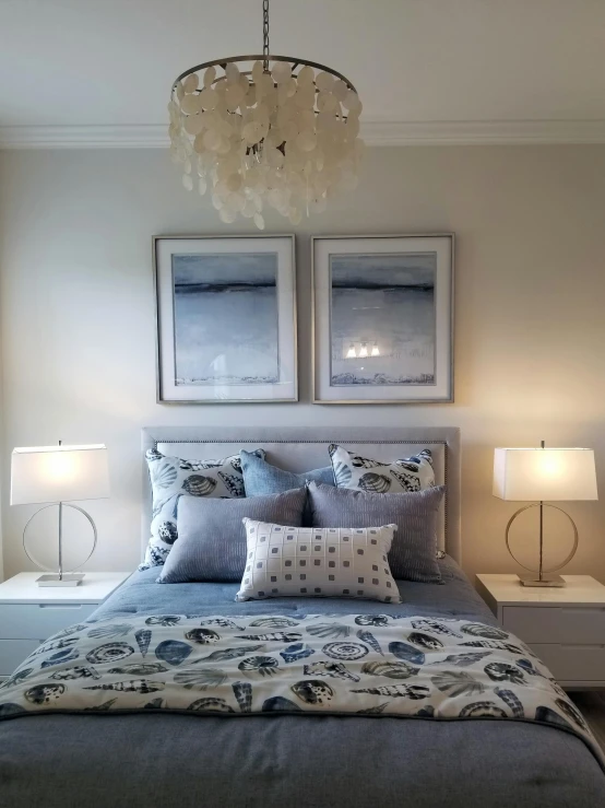 a large bed in a small room with a chandelier