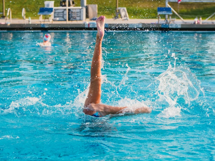 a woman that is playing in the water with a frisbee