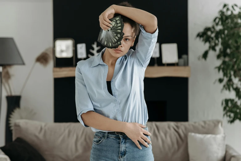 a woman standing holding up her head while looking at the camera