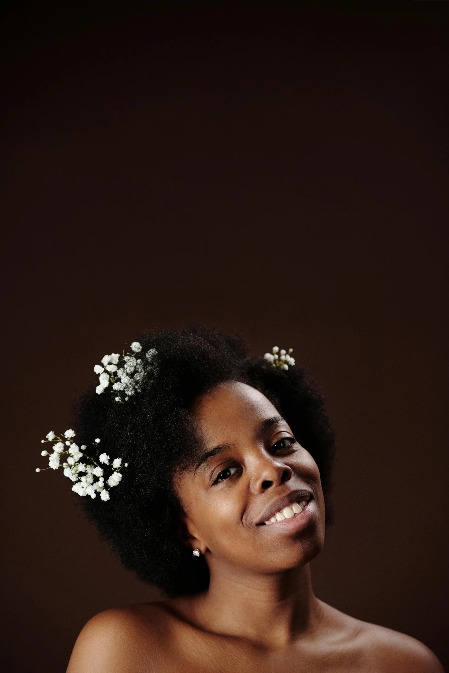 an african american girl smiles while wearing a small flower headband