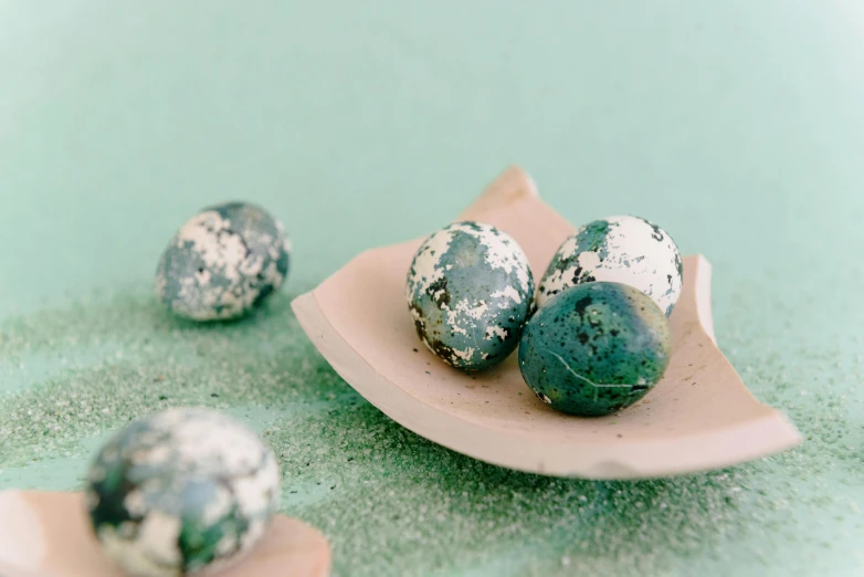 three balls are on a leafy, speckled dish