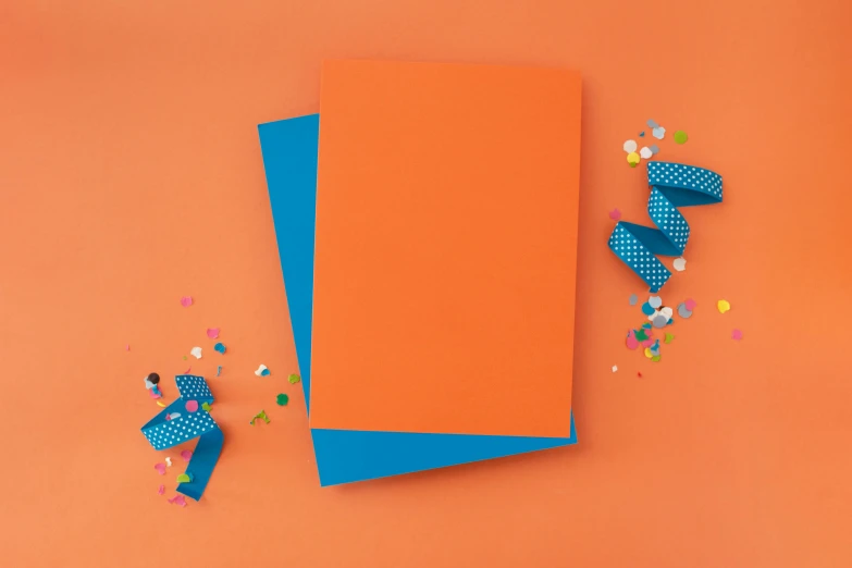 orange paper and small polka dot decorations against an orange background