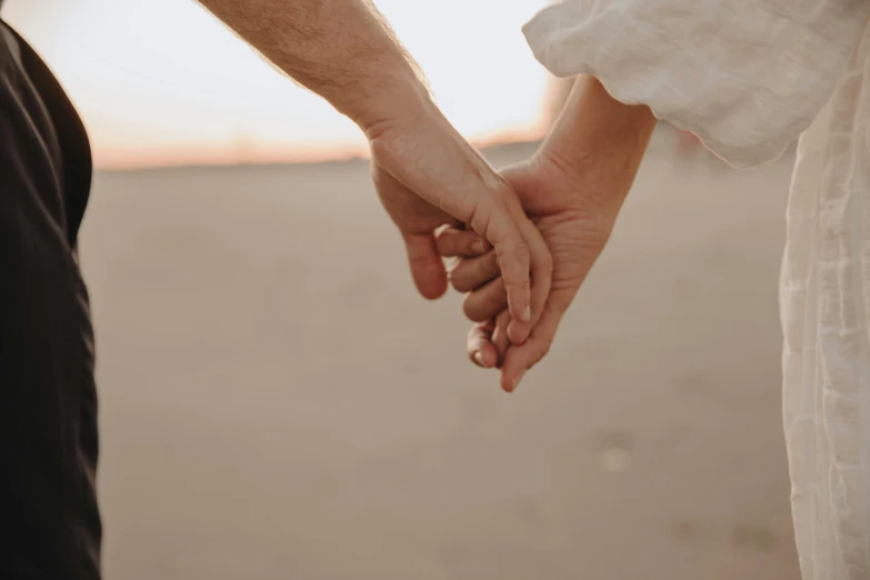 a close up of two people holding hands