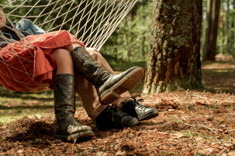 a girl laying in a hammock between two trees