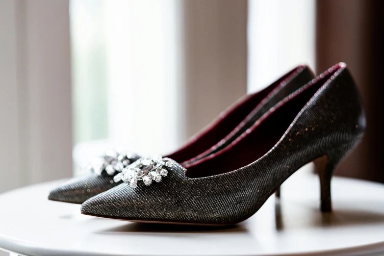 a pair of grey high heels on a white table