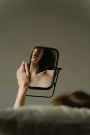 a woman is reflected in a mirror as she looks at herself