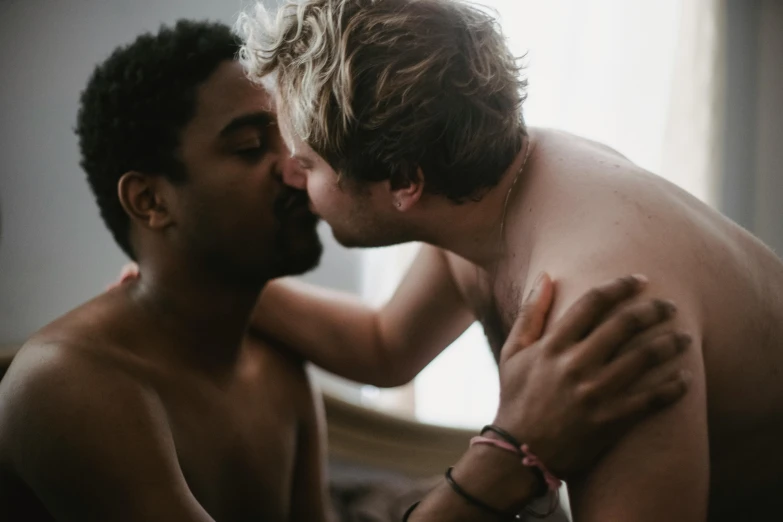 one male is kissing another mans face