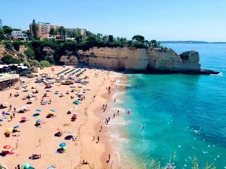 beach with people and many umbrellas next to the ocean