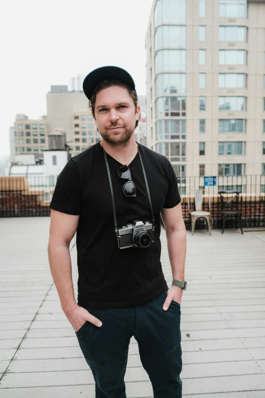 a man poses for a picture with his hands in his pockets