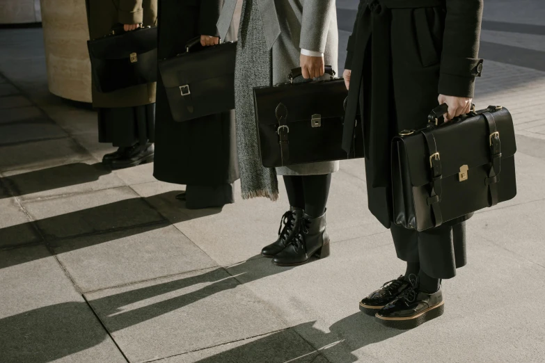 two woman standing on the sidewalk with some luggage