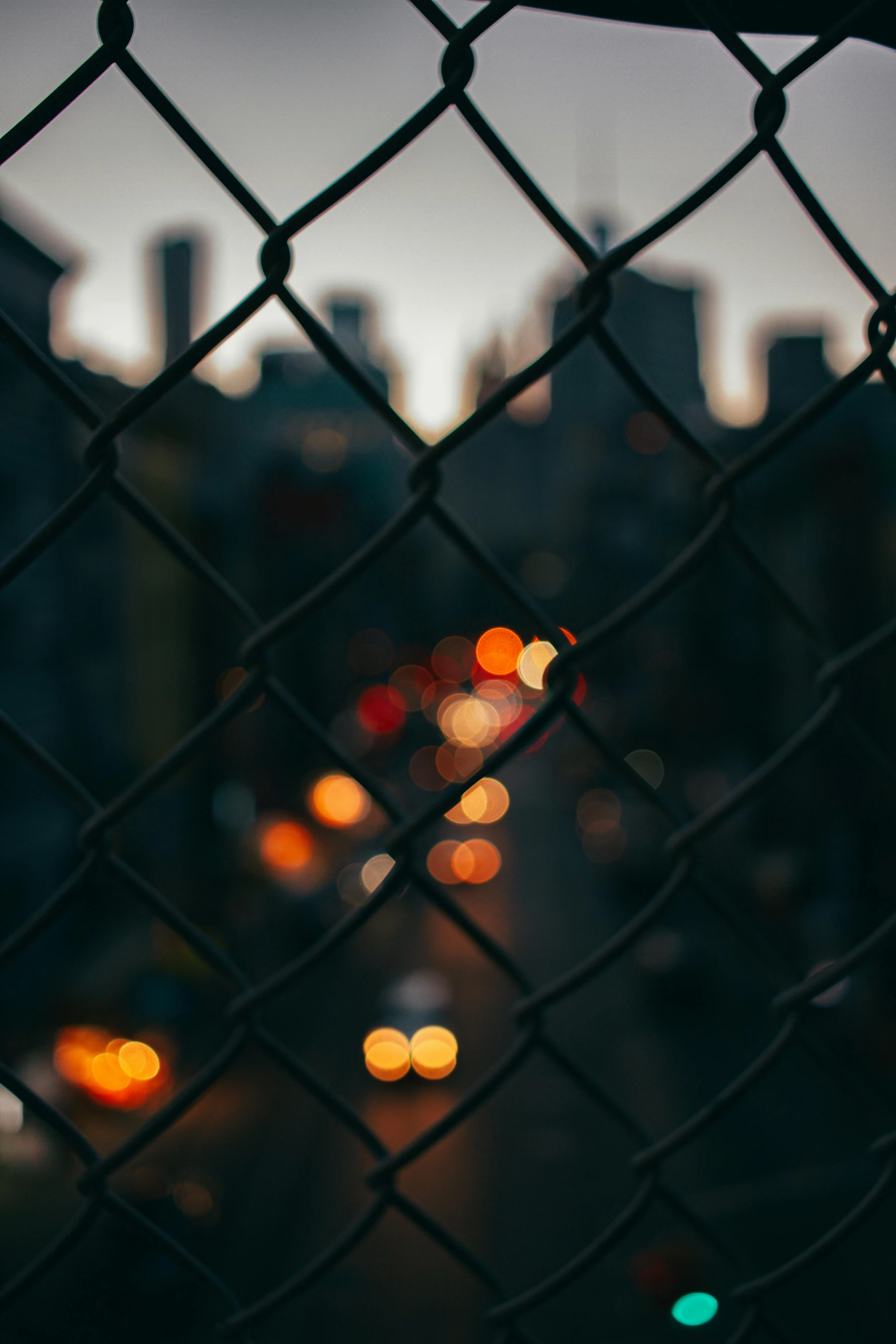 there is many cars on the road through the fence