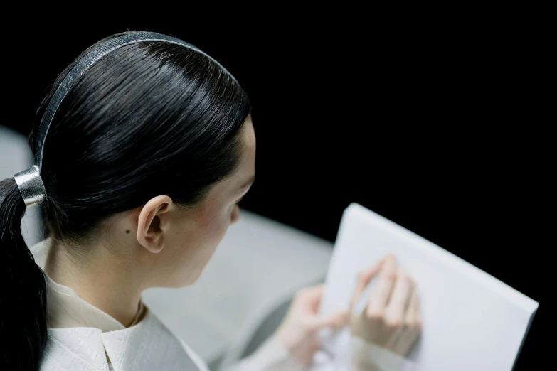 a woman that is sitting down with a book in her hand