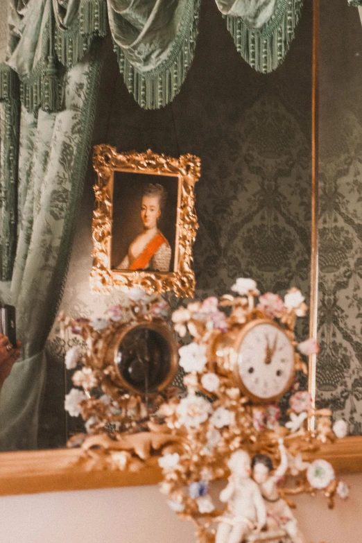 a clock, a portrait and a vase with flowers