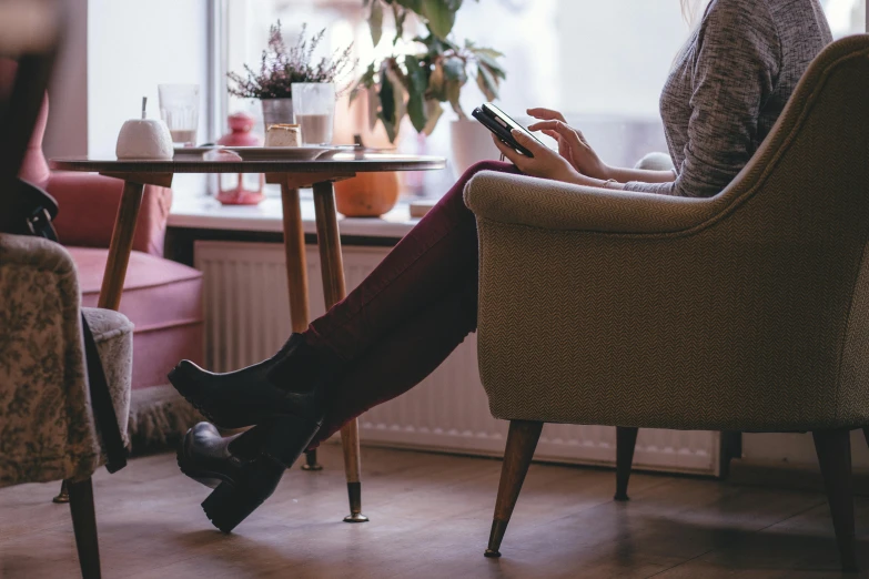 a woman sitting in a chair using her cell phone