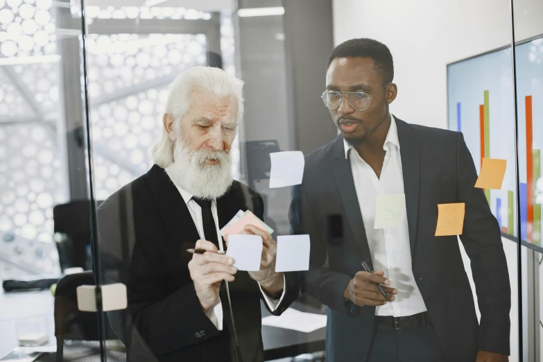 two men look at papers in a glass door