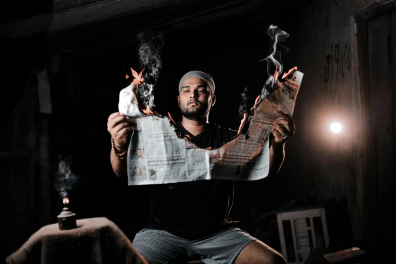 man holding up papers with candles in his hands