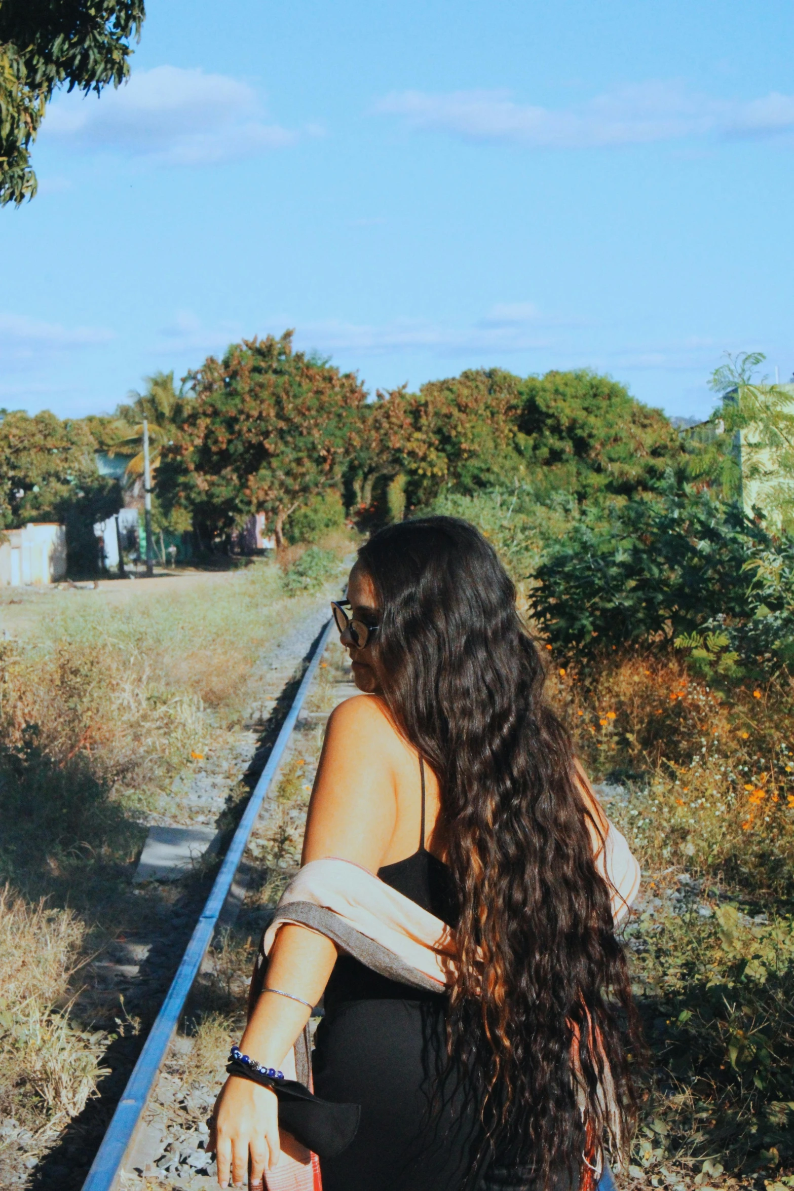 woman walking with a back pack down railroad tracks