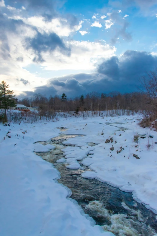 there is a small stream running through the snow