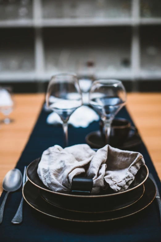 plates and forks on a table setting with glasses