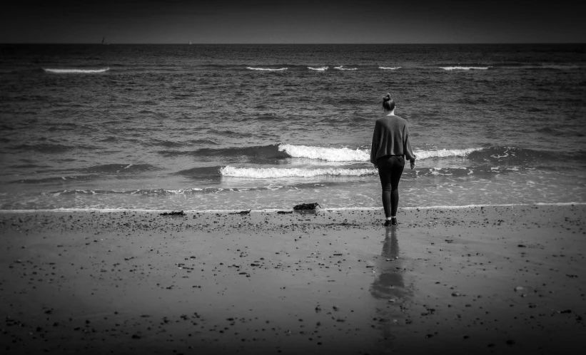 a person standing on the shore looking out at the ocean