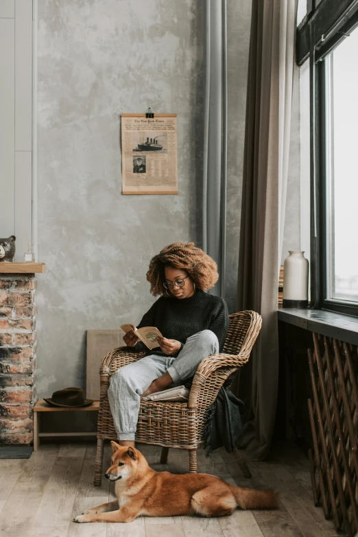 a person sitting on a chair next to a dog in the living room