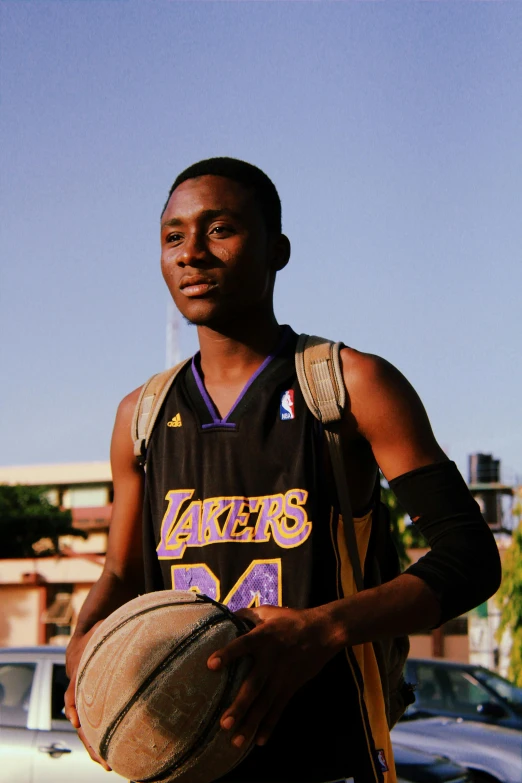 a young man wearing a jersey holding a basketball