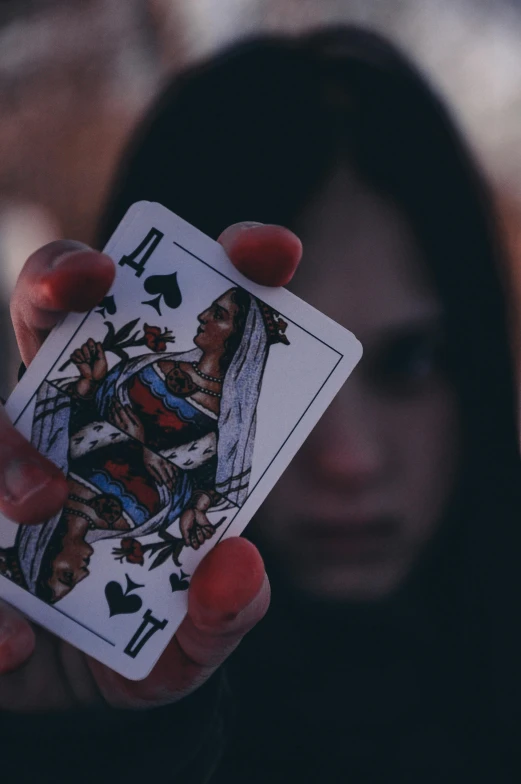 a woman holding up a deck of playing cards