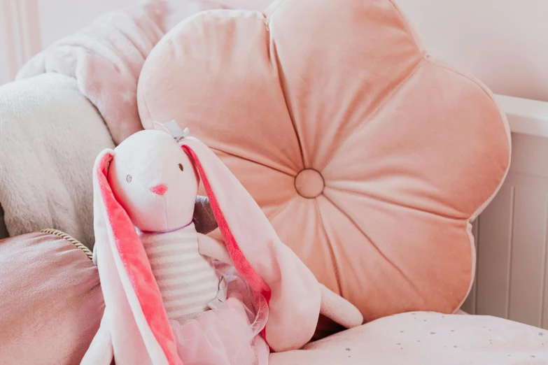 a little stuffed animal sitting on top of a bed