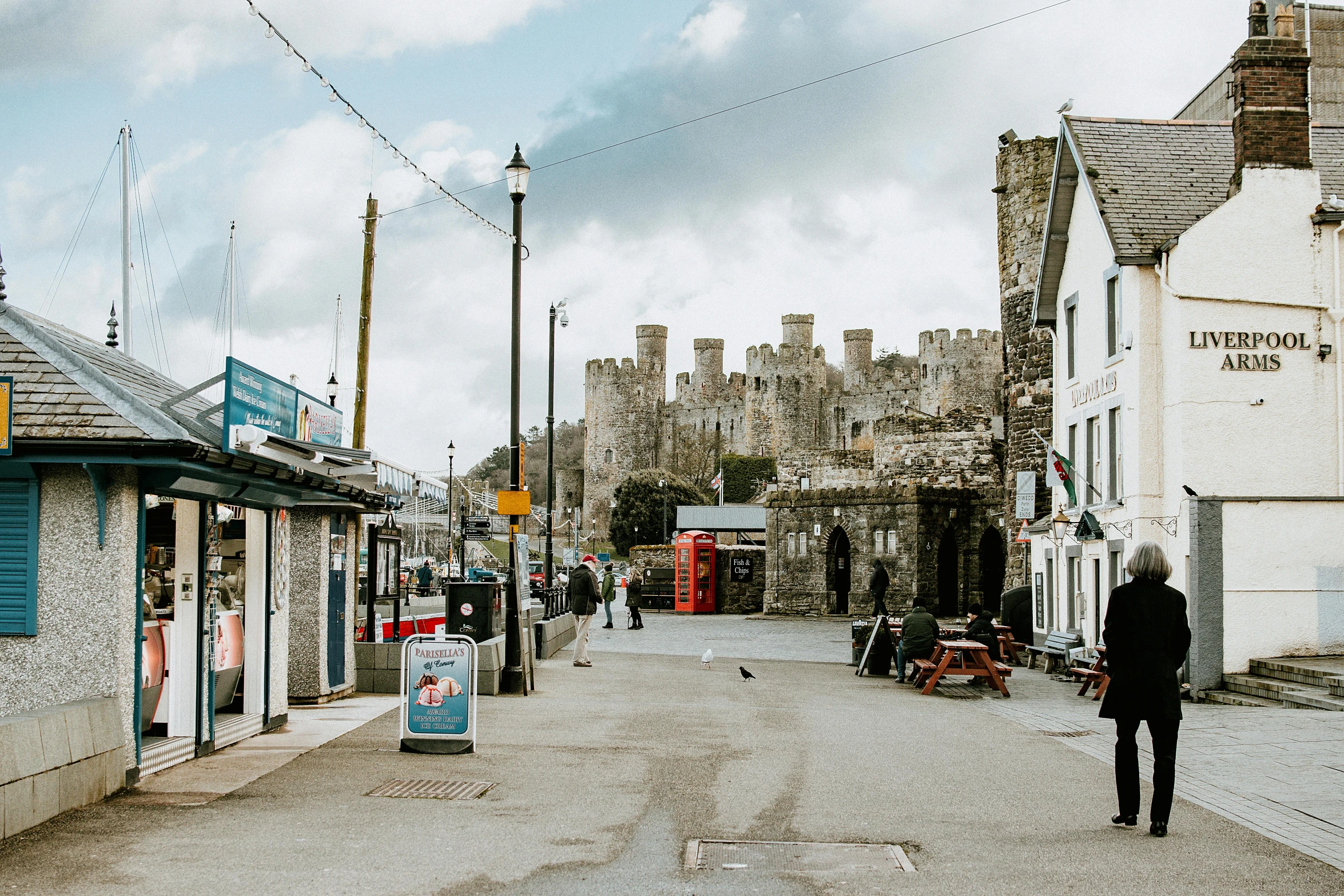 a man walking down an alley near a castle