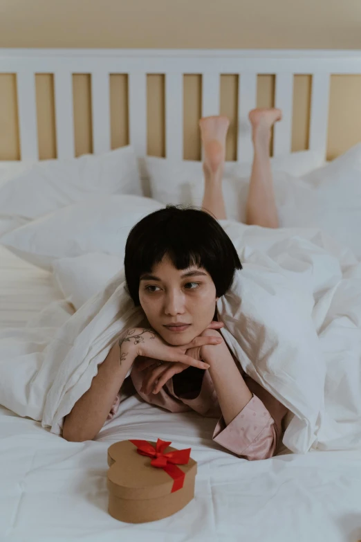 a woman laying in bed with pillows on her head