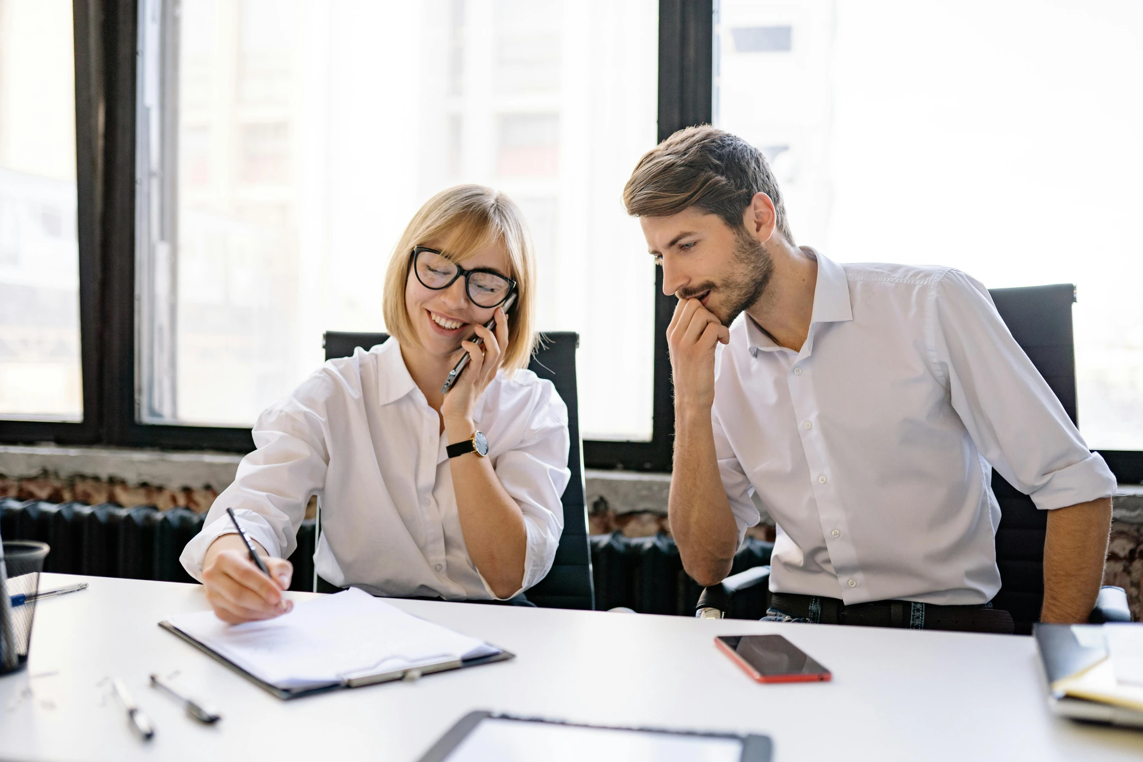 a man and woman are talking on a cell phone