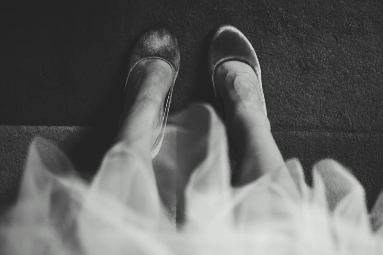 the legs of a woman wearing bridal shoes