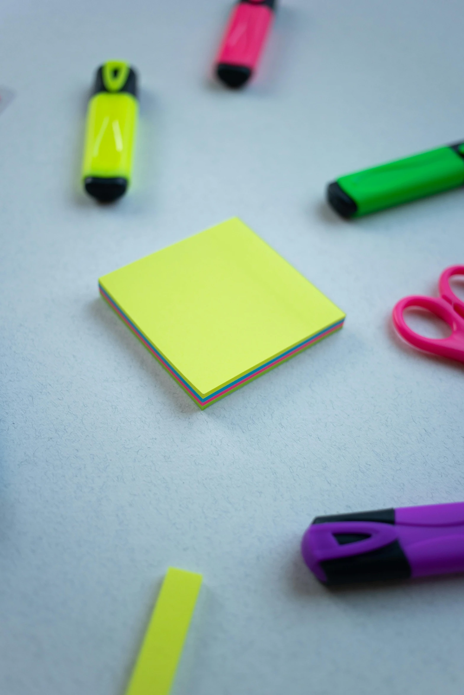 various colored stationary pens laying around a notepad