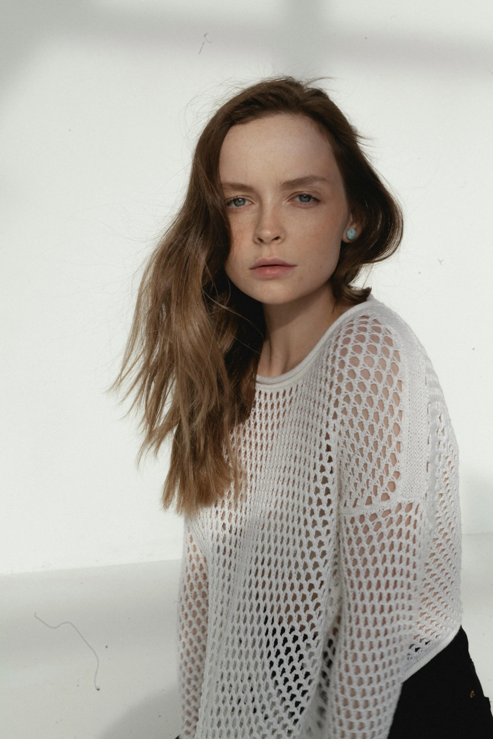 a woman with brown hair standing against a white background