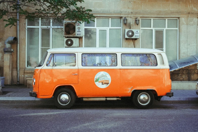an orange and white van is parked on the street