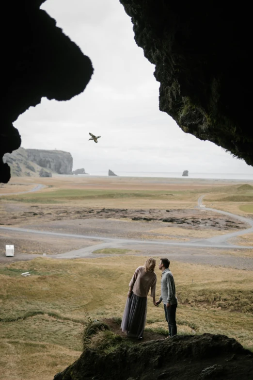 an image of two people standing together looking at the landscape