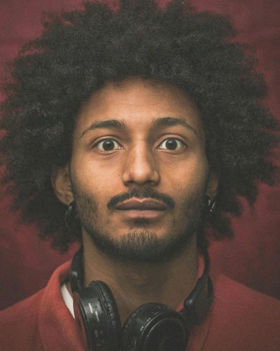 a young man with large black hair and earphones