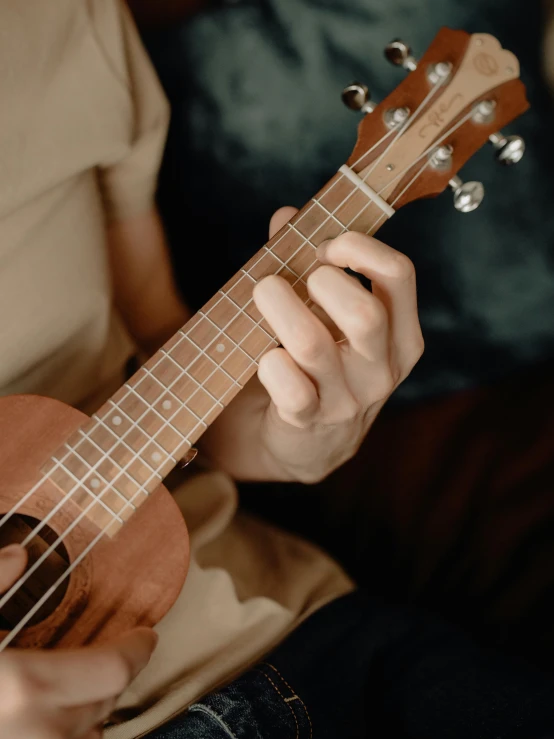 the woman is playing the ukulele on her fingers