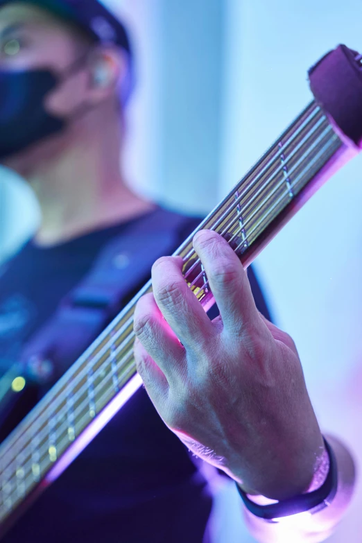 someone holding onto a guitar while wearing a blind