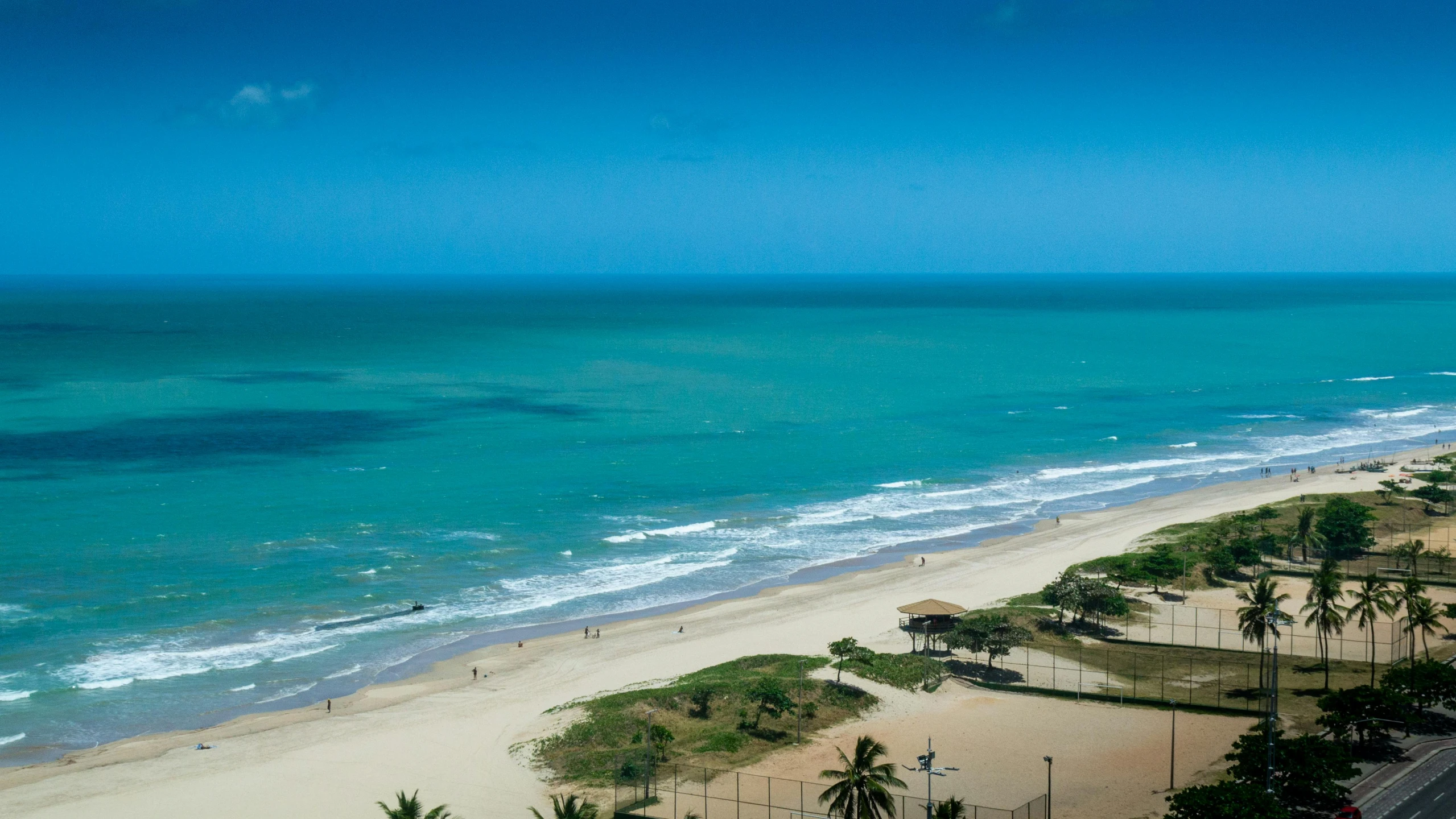 an ocean side view with beach and blue sky