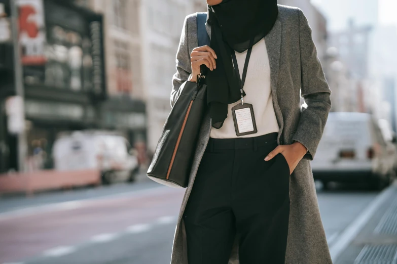 a woman in a black scarf standing on a sidewalk