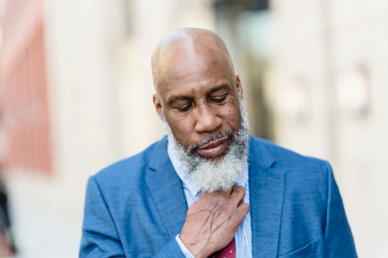 a bald man in a blue jacket and red tie