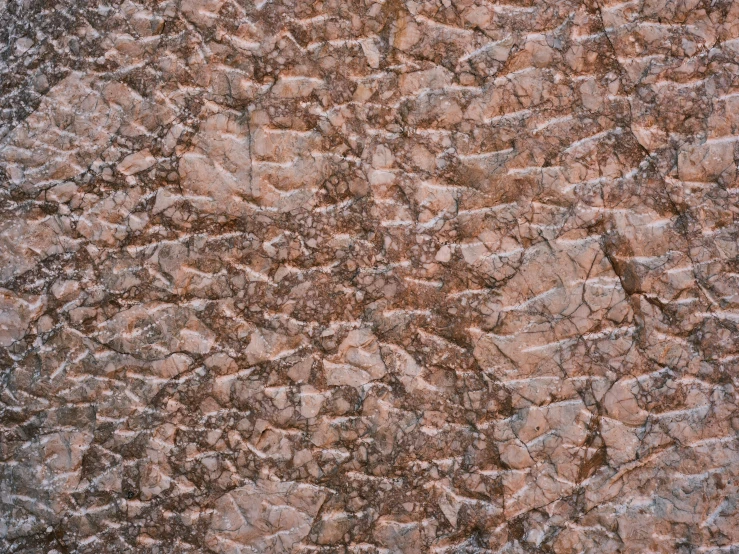 a textured wall that looks like a granite stone with brown, gray and white stains